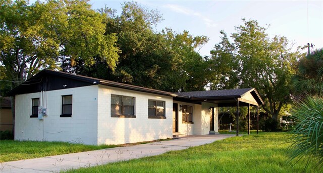 425 Walnut St, Daytona Beach, FL 32114 - view of front of property with driveway, an attached carport, and a front lawn