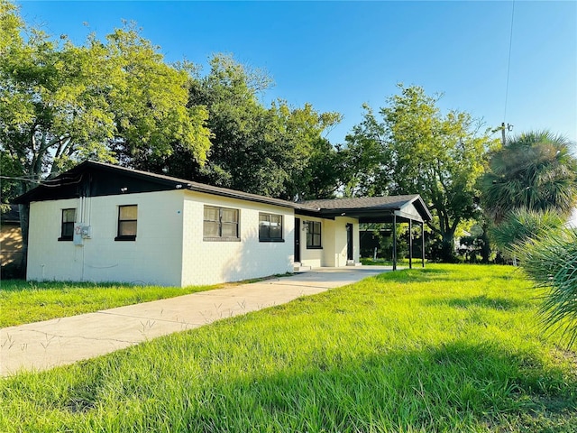 425 Walnut St, Daytona Beach, FL 32114 - ranch-style home with concrete driveway, a front lawn, and an attached carport