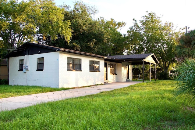 425 Walnut St, Daytona Beach, FL 32114 - ranch-style home with concrete driveway, a front lawn, and an attached carport