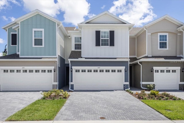 1267 Stockwell Ave, Saint Cloud, FL 34771 - view of front facade with an attached garage, board and batten siding, decorative driveway, and roof with shingles