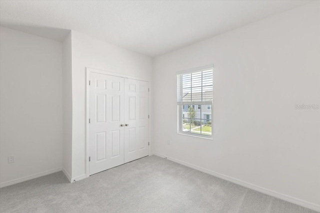 1267 Stockwell Ave, Saint Cloud, FL 34771 - unfurnished bedroom featuring light carpet and a closet