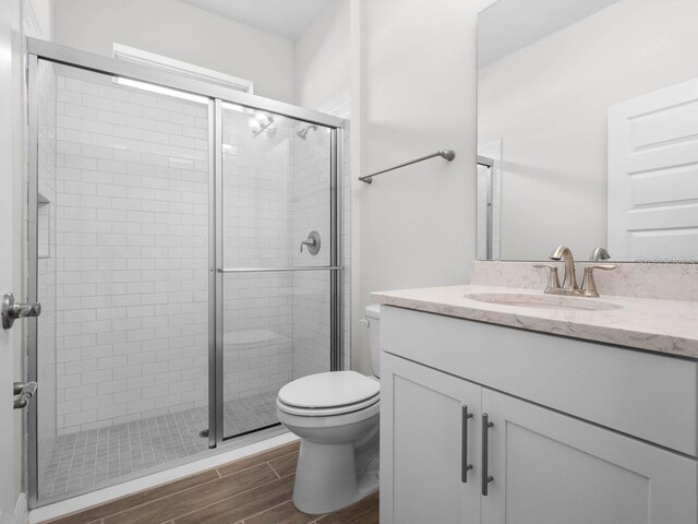 11027 Hollow Bay Dr, Winter Garden, FL 34787 - full bathroom featuring toilet, wood finished floors, vanity, and a stall shower