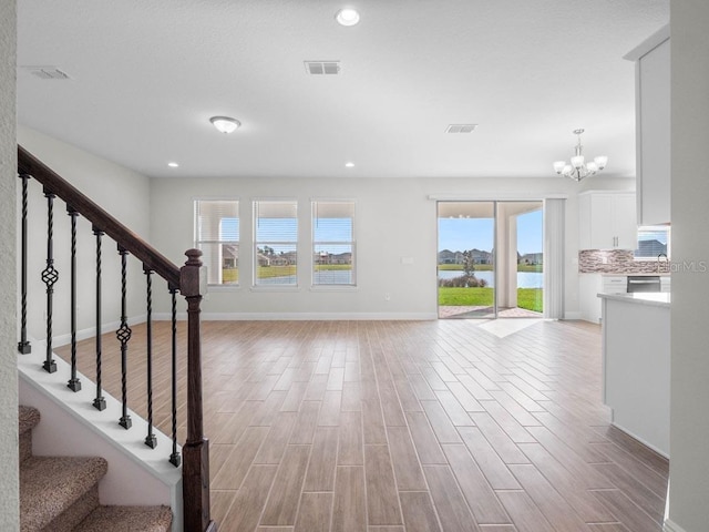 11027 Hollow Bay Dr, Winter Garden, FL 34787 - stairway with healthy amount of natural light, wood finished floors, a chandelier, and recessed lighting