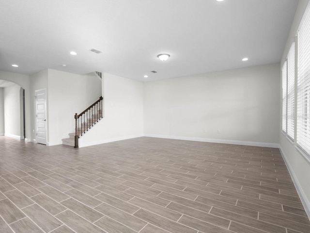 11027 Hollow Bay Dr, Winter Garden, FL 34787 - empty room with arched walkways, wood finished floors, stairs, baseboards, and recessed lighting