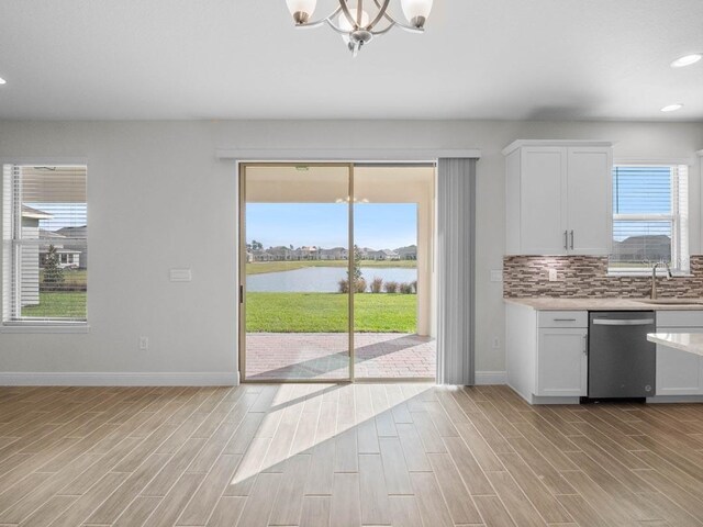11027 Hollow Bay Dr, Winter Garden, FL 34787 - kitchen with dishwasher, a chandelier, baseboards, light countertops, and plenty of natural light