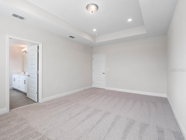 11027 Hollow Bay Dr, Winter Garden, FL 34787 - unfurnished bedroom with carpet flooring, baseboards, a tray ceiling, recessed lighting, and connected bathroom