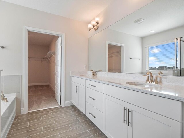 11027 Hollow Bay Dr, Winter Garden, FL 34787 - bathroom with a spacious closet, double vanity, a garden tub, and wood finished floors