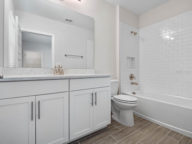 11027 Hollow Bay Dr, Winter Garden, FL 34787 - bathroom with toilet, wood finish floors, vanity, and washtub / shower combination