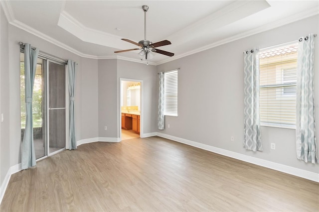 11322 Rapallo Ln, Windermere, FL 34786 - spare room featuring a tray ceiling, healthy amount of natural light, light wood-style floors, a ceiling fan, and crown molding