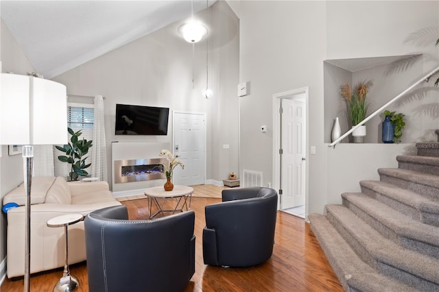 938 Southridge Trl, Altamonte Springs, FL 32714 - living room with high vaulted ceiling, wood finished floors, stairway, and a glass covered fireplace