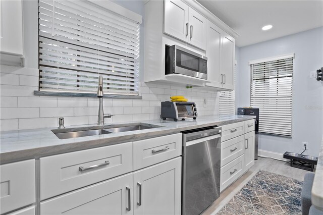 938 Southridge Trl, Altamonte Springs, FL 32714 - kitchen featuring appliances with stainless steel finishes, a sink, white cabinetry, light stone counters, and recessed lighting