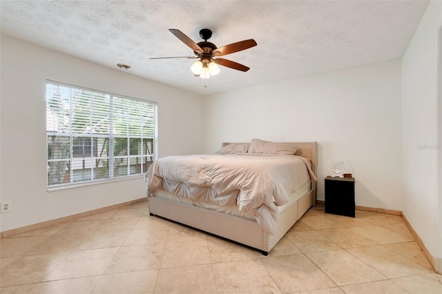 5323 Hansel Ave Unit E14, Orlando, FL 32809 - bedroom with baseboards, light tile patterned floors, a ceiling fan, and a textured ceiling