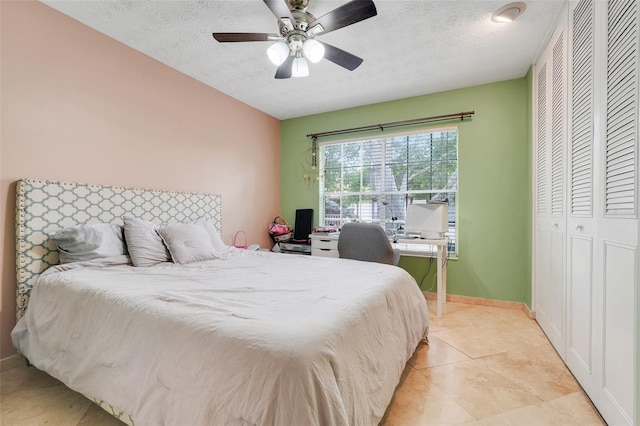 5323 Hansel Ave Unit E14, Orlando, FL 32809 - bedroom with a textured ceiling, light tile patterned flooring, a closet, ceiling fan, and baseboards