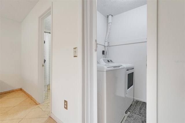 5323 Hansel Ave Unit E14, Orlando, FL 32809 - laundry area featuring independent washer and dryer, baseboards, and light tile patterned floors