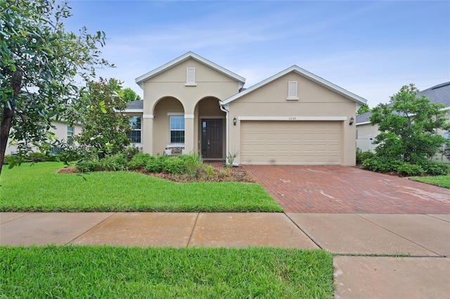 2339 Jernigan Loop, Kissimmee, FL 34746 - traditional-style house featuring stucco siding, decorative driveway, an attached garage, and a front yard