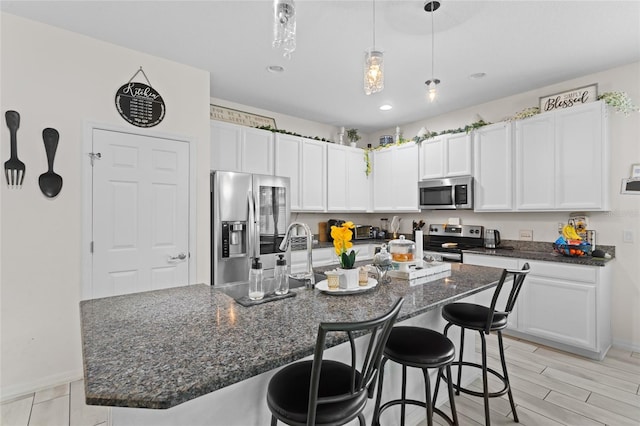 2339 Jernigan Loop, Kissimmee, FL 34746 - kitchen featuring appliances with stainless steel finishes, white cabinets, a kitchen breakfast bar, pendant lighting, and baseboards