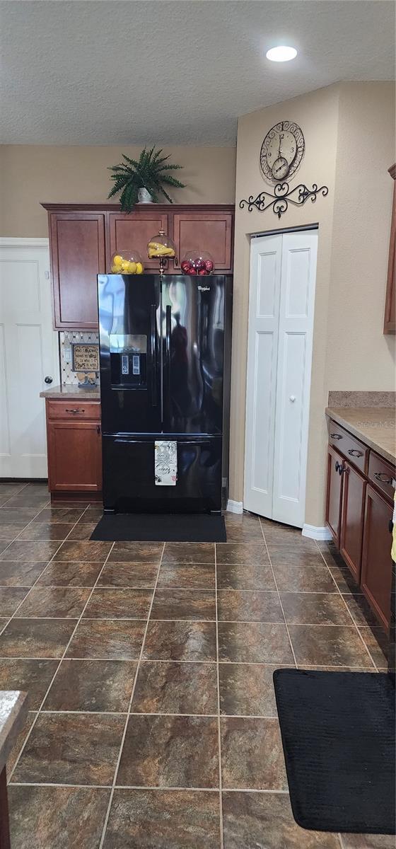 7620 Tangle Rush Dr, Gibsonton, FL 33534 - kitchen featuring black fridge with ice dispenser, a textured ceiling, baseboards, and recessed lighting