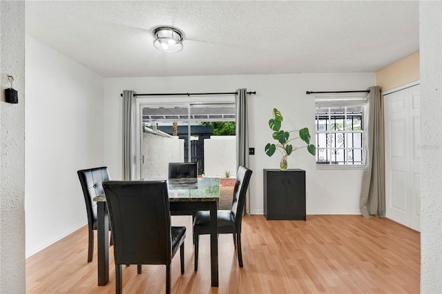 5662 Royal Pine Blvd Unit 24, Orlando, FL 32807 - dining room featuring light wood-type flooring, baseboards, and a textured ceiling