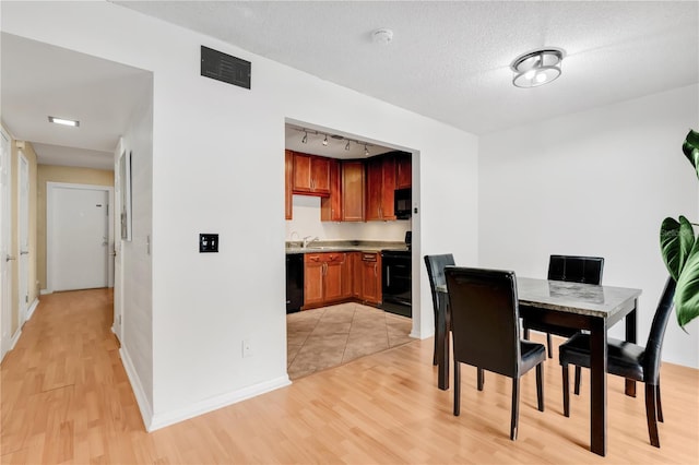 5662 Royal Pine Blvd Unit 24, Orlando, FL 32807 - dining area with light wood-style flooring, baseboards, and rail lighting