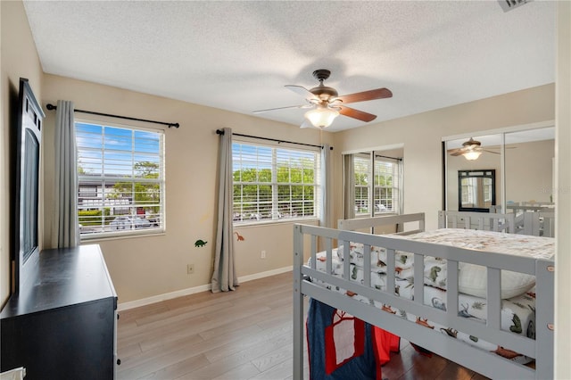 5662 Royal Pine Blvd Unit 24, Orlando, FL 32807 - bedroom with baseboards, light wood-style floors, a textured ceiling, and a ceiling fan