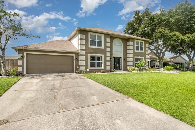 16012 Lanesboro Ct, Clermont, FL 34711 - view of front of house featuring a front lawn, driveway, a garage, and stucco siding