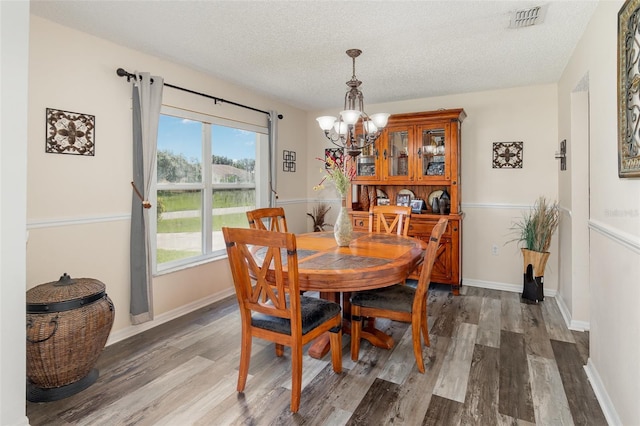 16012 Lanesboro Ct, Clermont, FL 34711 - dining area featuring a chandelier, wood finished floors, a textured ceiling, and baseboards