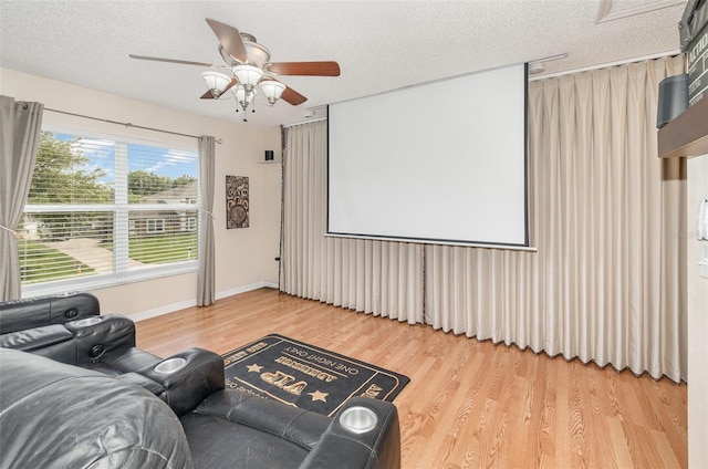 16012 Lanesboro Ct, Clermont, FL 34711 - cinema room with wood finished floors, a ceiling fan, a textured ceiling, and baseboards