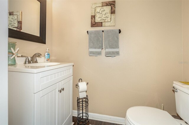 16012 Lanesboro Ct, Clermont, FL 34711 - half bathroom featuring toilet, vanity, baseboards, and wood finished floors