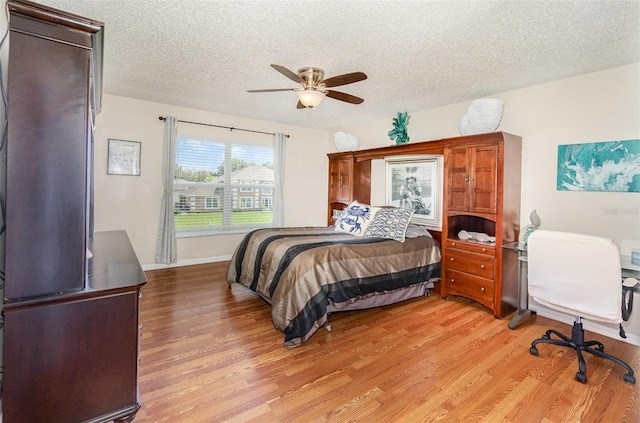 16012 Lanesboro Ct, Clermont, FL 34711 - bedroom featuring light wood finished floors, a textured ceiling, a ceiling fan, and baseboards