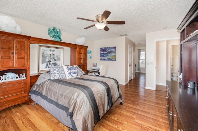 16012 Lanesboro Ct, Clermont, FL 34711 - bedroom featuring light wood finished floors, a textured ceiling, baseboards, and a ceiling fan