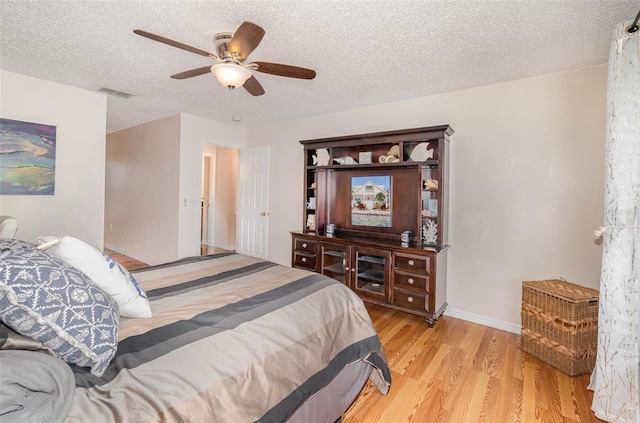16012 Lanesboro Ct, Clermont, FL 34711 - bedroom with light wood-style floors, a textured ceiling, ceiling fan, and baseboards
