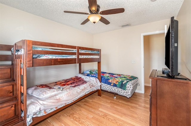 16012 Lanesboro Ct, Clermont, FL 34711 - bedroom featuring light wood finished floors, a textured ceiling, a ceiling fan, and baseboards