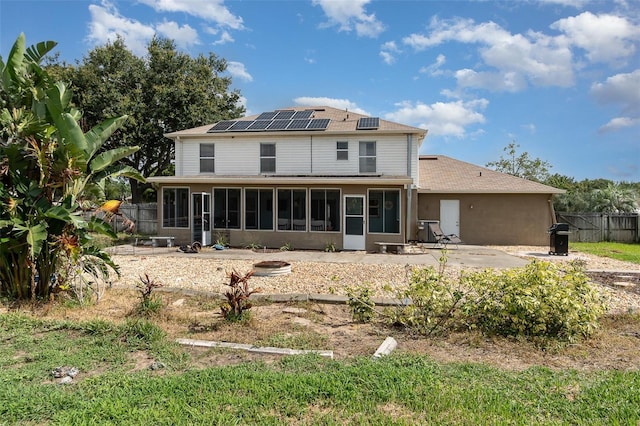 16012 Lanesboro Ct, Clermont, FL 34711 - rear view of property featuring a sunroom, roof mounted solar panels, and a shingled roof