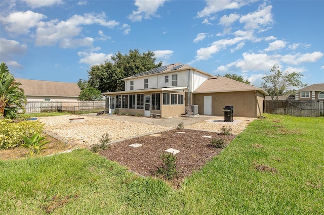 16012 Lanesboro Ct, Clermont, FL 34711 - rear view of house featuring a sunroom, a patio area, stucco siding, and roof mounted solar panels