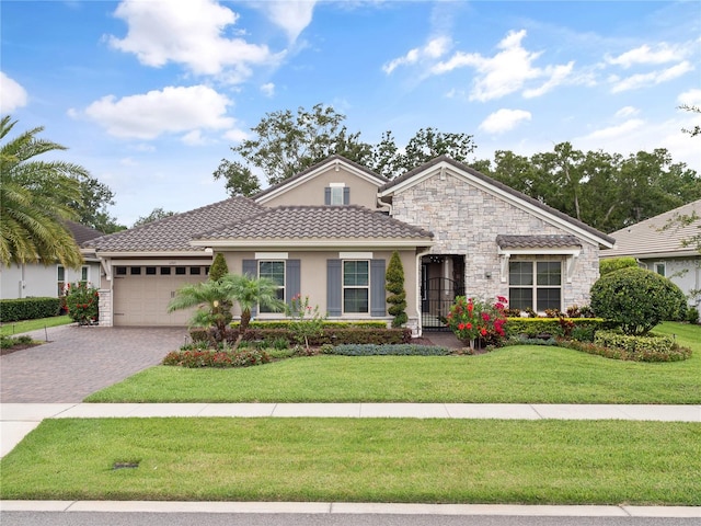 1265 Estancia Woods Loop, Windermere, FL 34786 - view of front facade with stucco siding, an attached garage, a front yard, decorative driveway, and stone siding