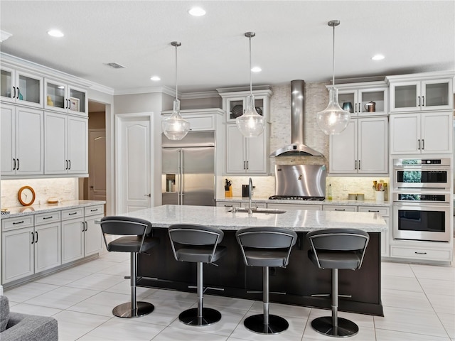 1265 Estancia Woods Loop, Windermere, FL 34786 - kitchen featuring appliances with stainless steel finishes, wall chimney range hood, decorative backsplash, ornamental molding, and light tile patterned flooring