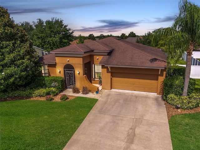 3562 Foxchase Dr, Clermont, FL 34711 - view of front facade with stucco siding, a garage, driveway, a front lawn, and roof with shingles