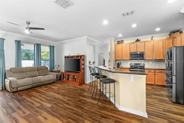 3562 Foxchase Dr, Clermont, FL 34711 - kitchen with stainless steel appliances, ornamental molding, dark wood finished floors, a breakfast bar, and recessed lighting