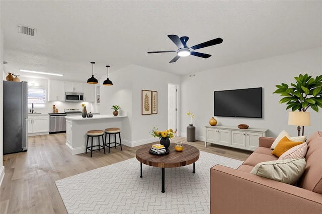 324 James Pl, Saint Cloud, FL 34769 - living room with light wood-type flooring, a ceiling fan, and baseboards