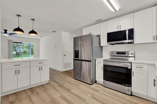 324 James Pl, Saint Cloud, FL 34769 - kitchen with stainless steel appliances, light countertops, white cabinetry, and a textured ceiling