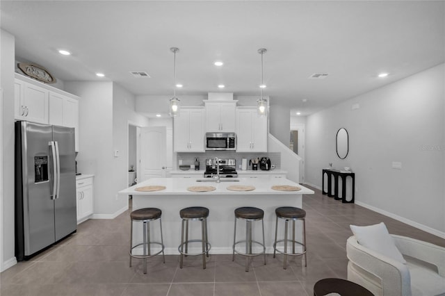 1932 Terrapin Rd, Ocoee, FL 34761 - kitchen featuring appliances with stainless steel finishes, a kitchen breakfast bar, light countertops, light tile patterned flooring, and recessed lighting