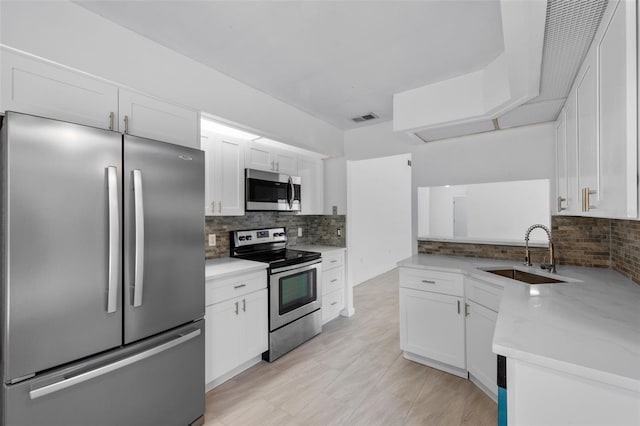 309 Kirkcaldy Dr, Winter Springs, FL 32708 - kitchen with appliances with stainless steel finishes, a sink, decorative backsplash, and white cabinetry