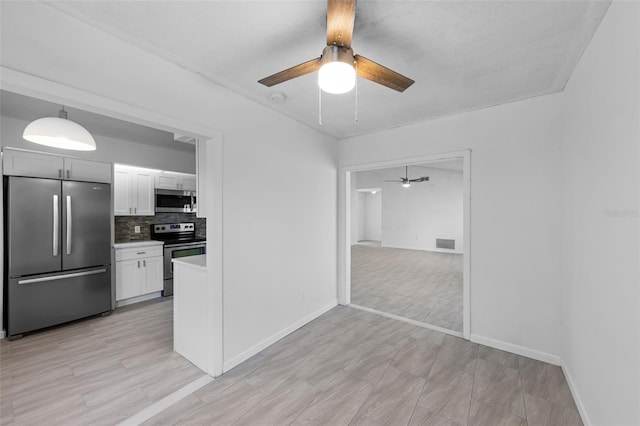 309 Kirkcaldy Dr, Winter Springs, FL 32708 - kitchen with stainless steel appliances, ceiling fan, white cabinets, and backsplash