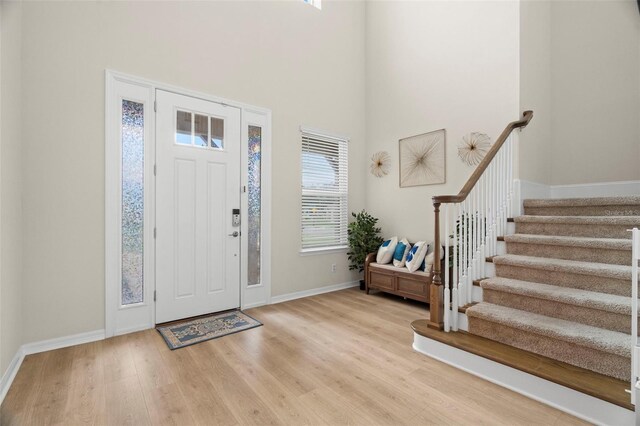 7163 Talamore Dr, Wesley Chapel, FL 33545 - foyer entrance with a high ceiling, wood finished floors, stairs, and baseboards
