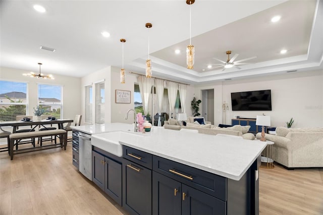7163 Talamore Dr, Wesley Chapel, FL 33545 - kitchen with a sink, open floor plan, a tray ceiling, light wood-type flooring, and recessed lighting