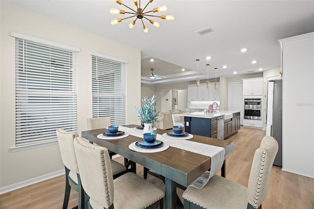 7163 Talamore Dr, Wesley Chapel, FL 33545 - dining area featuring light wood-style flooring, a chandelier, baseboards, recessed lighting, and a raised ceiling