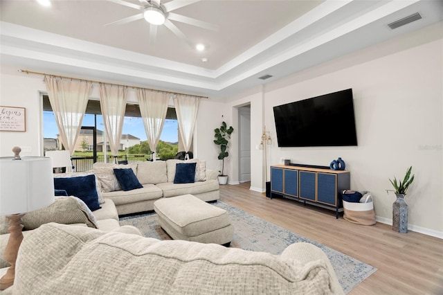 7163 Talamore Dr, Wesley Chapel, FL 33545 - living area featuring ceiling fan, light wood-style flooring, baseboards, recessed lighting, and a tray ceiling