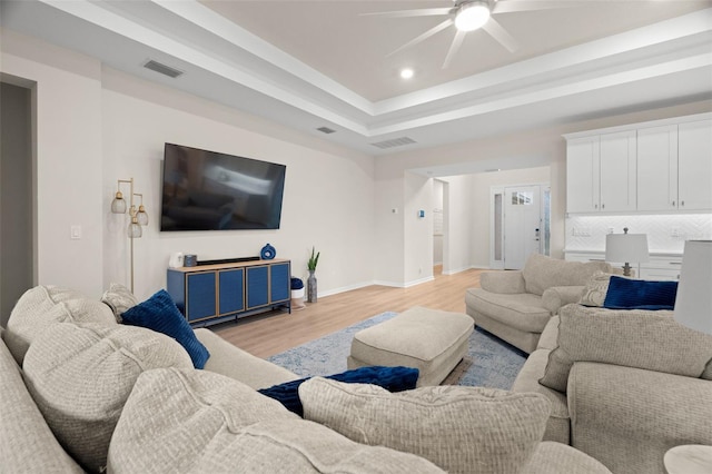 7163 Talamore Dr, Wesley Chapel, FL 33545 - living room featuring a ceiling fan, light wood-type flooring, baseboards, recessed lighting, and a tray ceiling