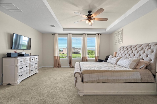 7163 Talamore Dr, Wesley Chapel, FL 33545 - bedroom with a tray ceiling, light carpet, baseboards, and a ceiling fan