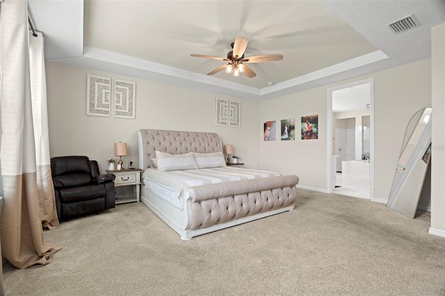 7163 Talamore Dr, Wesley Chapel, FL 33545 - carpeted bedroom with a raised ceiling, baseboards, ensuite bath, and a ceiling fan